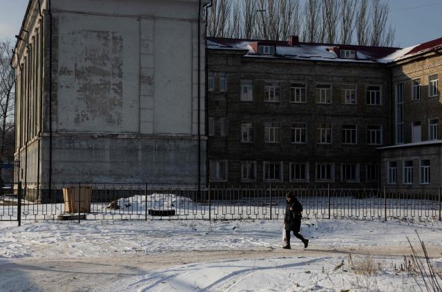 A woman walks along a street in Kramatorsk, eastern Ukraine on January 20, 2026, amid the Russian invasion of Ukraine. (Photo by Tetiana DZHAFAROVA / AFP)