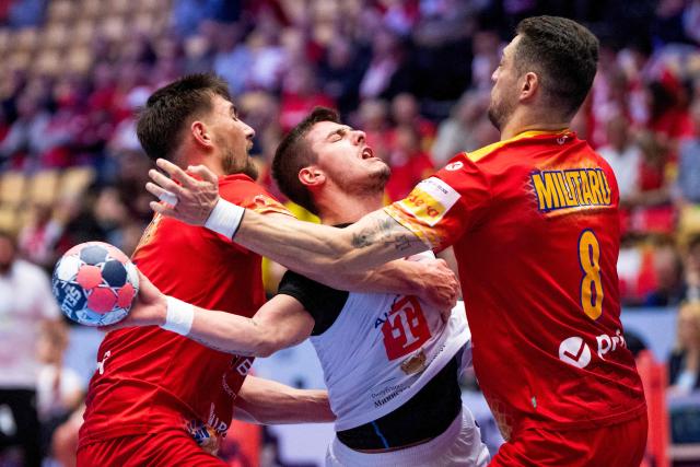 North Macedonia's centre back #10 Marko Mitev (C) and Romania's left back #08 Robert Militaru (R) vie during the EHF Euro 2026 Group B preliminary round handball match between North Macedonia and Romania in Herning, Denmark, on January 20, 2026. (Photo by Bo Amstrup / Ritzau Scanpix / AFP) / Denmark OUT
