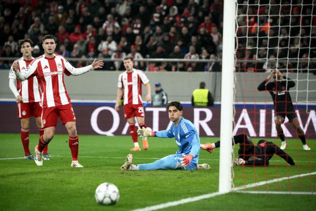Olympiakos' Greek goalkeeper #88 Kostas Tzolakis (R) eyes the ball flying past his goal during the during the UEFA Champions League, league phase day 7, football match between Olympiakos and Bayer Leverkusen at the Georgios Karaiskakis Stadium in Piraeus, near Athens, on January 20, 2026. (Photo by Angelos Tzortzinis / AFP)