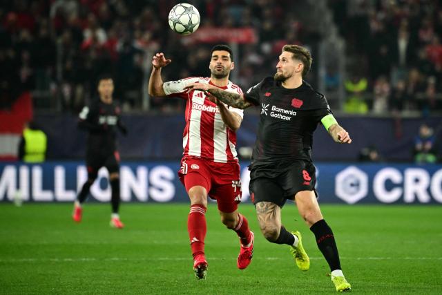 Bayer Leverkusen's German midfielder #08 Robert Andrich (R) fights for the ball with Olympiakos' Iranian forward #99 Mehdi Taremi during the during the UEFA Champions League, league phase day 7, football match between Olympiakos and Bayer Leverkusen at the Georgios Karaiskakis Stadium in Piraeus, near Athens, on January 20, 2026. (Photo by Angelos Tzortzinis / AFP)