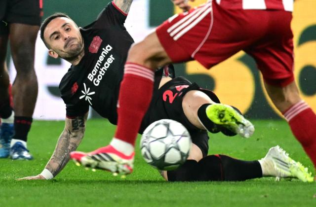 Bayer Leverkusen's Spanish midfielder #24 Alex Garcia tackles the ball during the during the UEFA Champions League, league phase day 7, football match between Olympiakos and Bayer Leverkusen at the Georgios Karaiskakis Stadium in Piraeus, near Athens, on January 20, 2026. (Photo by Angelos Tzortzinis / AFP)