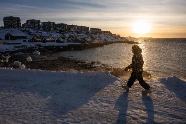 A man walks on the shoreline in Nuuk, Greenland, on January 20, 2026. (Photo by Jonathan NACKSTRAND / AFP)