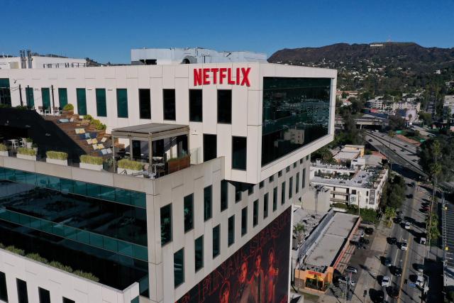 (FILES) This aerial picture taken on December 5, 2025, shows the Netflix logo above Hollywood studio offices at Sunset Bronson Studios as the Hollywood sign stands on the horizon in Los Angeles, California. Netflix shares fell more than five percent on January 20, 2026 as the streaming entertainment giant said it expected revenue to be essentially flat in the current quarter after years of growth. (Photo by Patrick T. Fallon / AFP)