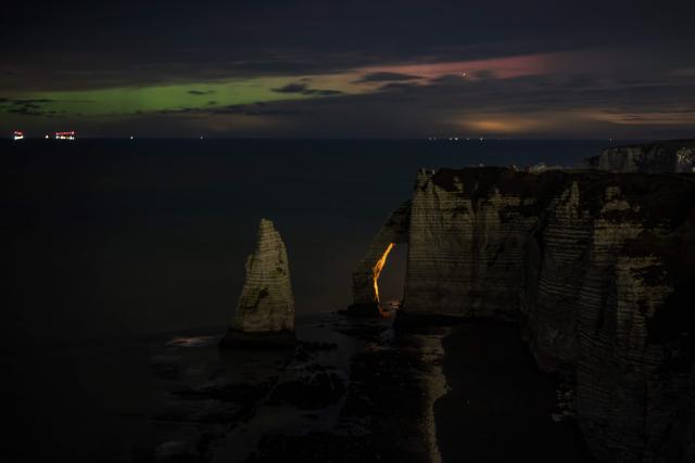 TOPSHOT - This photograph shows the hollow needle cliffs of Etretat during an Aurora Borealis, or Northern Lights, in Etretat, northwestern France, on January 20, 2026. (Photo by LOU BENOIST / AFP)