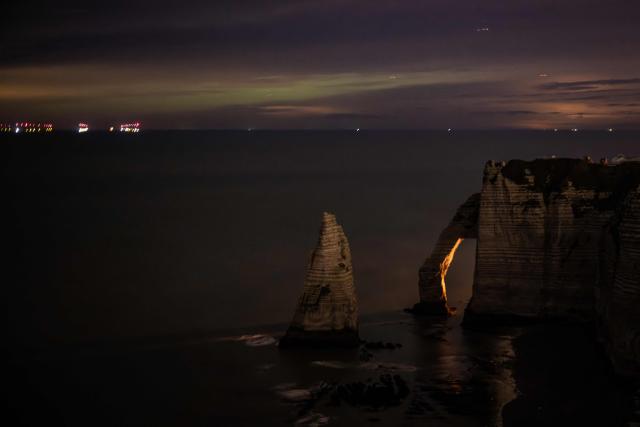 This photograph shows the hollow needle cliffs of Etretat during an Aurora Borealis, or Northern Lights, in Etretat, northwestern France, on January 20, 2026. (Photo by LOU BENOIST / AFP)