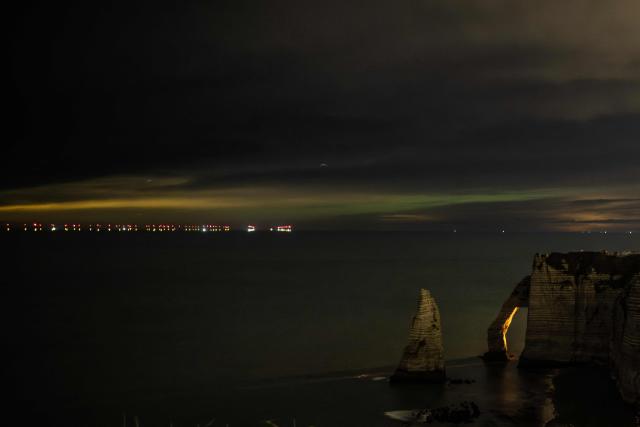 TOPSHOT - This photograph shows the hollow needle cliffs of Etretat during an Aurora Borealis, or Northern Lights, in Etretat, northwestern France, on January 20, 2026. (Photo by LOU BENOIST / AFP)