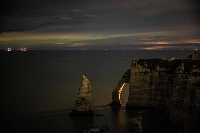 This photograph shows the hollow needle cliffs of Etretat during an Aurora Borealis, or Northern Lights, in Etretat, northwestern France, on January 20, 2026. (Photo by LOU BENOIST / AFP)