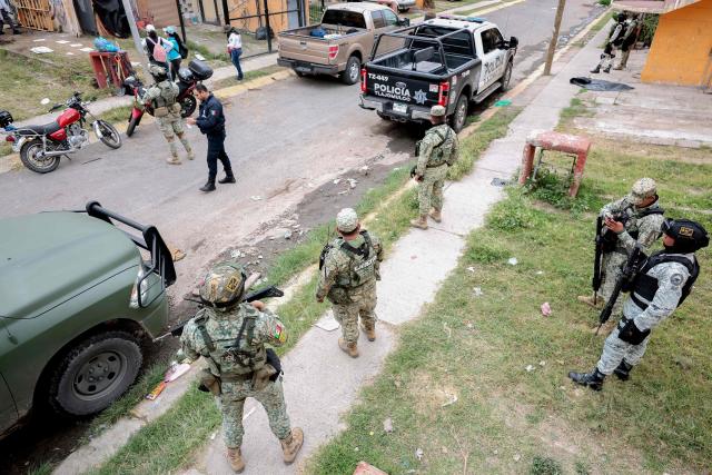 Mexican soldiers guard the area where the "Guerreros Buscadores" (Searching Warriors) collective search bodies near a drug house in Tlajomulco de Zuniga, Jalisco state, Mexico on January 20, 2026. The Mexican collective "Guerreros Buscadores" went to an area near a drug house in Tlajomulco de Zuniga after receiving an anonymous tip that several bodies had recently been buried there, while the National Guard arrested one suspect. (Photo by Ulises RUIZ / AFP)