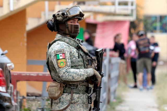 A Mexican soldier guards the area where the "Guerreros Buscadores" (Searching Warriors) collective search bodies search for bodies near a drug house in Tlajomulco de Zuniga, Jalisco state, Mexico on January 20, 2026. The Mexican collective "Guerreros Buscadores" went to an area near a drug house in Tlajomulco de Zuniga after receiving an anonymous tip that several bodies had recently been buried there, while the National Guard arrested one suspect. (Photo by Ulises RUIZ / AFP)