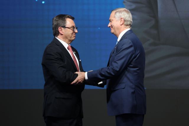 Chile's President-elect Jose Antonio Kast (R) greets Fernando Barros as new Minister of Defense during the presentation of his cabinet at the office of the president-elect, commonly nicknamed 'La Moneda Chica,' in Las Condes, Santiago, on January 20, 2026. Chile's right-wing president-elect Jose Antonio Kast on january 20 named two ex-lawyers of former dictator Augusto Pinochet to lead the ministries of defense and human rights when he takes office in March. (Photo by Alvaro NARANJO / AFP)