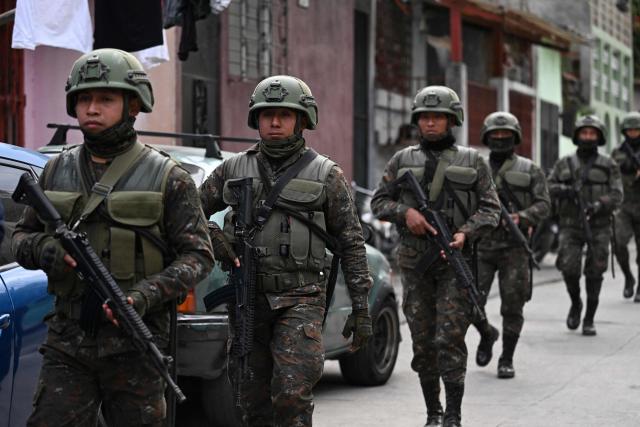 Guatemalan Army soldiers patrol a street of the Nueva Jerusalen neighborhood during the state of emergency declared by the government in Guatemala City on January 20, 2026. Guatemalan soldiers began patrolling gang-controlled neighborhoods in the capital on Tuesday, after attacks that left ten police officers dead and prompted the government to declare a state of siege, according to official sources and an AFP journalist. (Photo by JOHAN ORDONEZ / AFP)