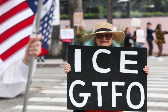 A demonstrator holds a sign during the Free America Walkout to protest against Immigration and Customs Enforcement (ICE) and US President Donald Trump's policies in the Venice Beach neighborhood of Los Angeles, California on January 20, 2026. (Photo by Patrick T. Fallon / AFP)