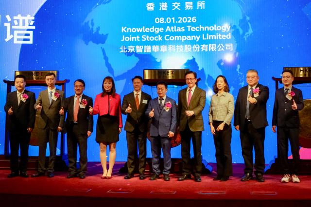(FILES) Company chairman Liu Debing (5th R) and attendees pose during the initial public offering (IPO) launch of one of the largest large language model developers in China, Zhipu AI, or Knowledge Atlas Technology, at the Hong Kong Stock Exchange (HKEX) on January 8, 2026. Investor confidence in Chinese AI startups is riding high, but obstacles to their long-term success range from US export controls to the puzzle of how to become profitable. (Photo by Tommy WANG / AFP)