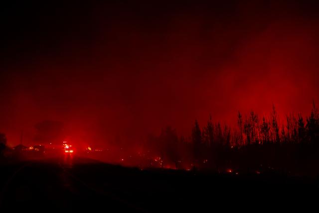 Fire engines are seen next to a wildfire in the town of Florida near the city of Concepción, Chile, on January 20, 2026. Residents of southern Chile, ravaged by four days of deadly wildfires, pleaded for help on January 20 from communities reduced to rubble, as smoke lingered and firefighters braced for the return of hot weather. (Photo by Raul BRAVO / AFP)
