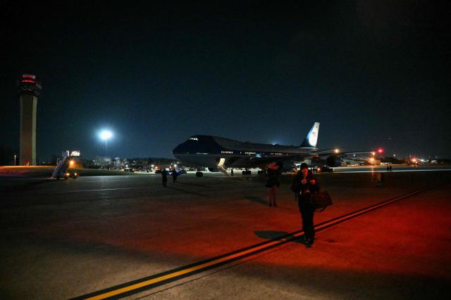 Journalists are seen walking away from Air Force One on the tarmac at Joint Base Andrews in Maryland on January 20, 2026 after it was forced to return to the air base due to a "minor electrical issue" shortly after departing for Switzerland, the White House said. Air Force One returned to Joint Base Andrews out of an abundance of caution, Press Secretary Karoline Leavitt said, where Trump and his entourage will switch to another plane and continue the trip to the World Economic Forum in Davos. (Photo by Mandel NGAN / AFP)