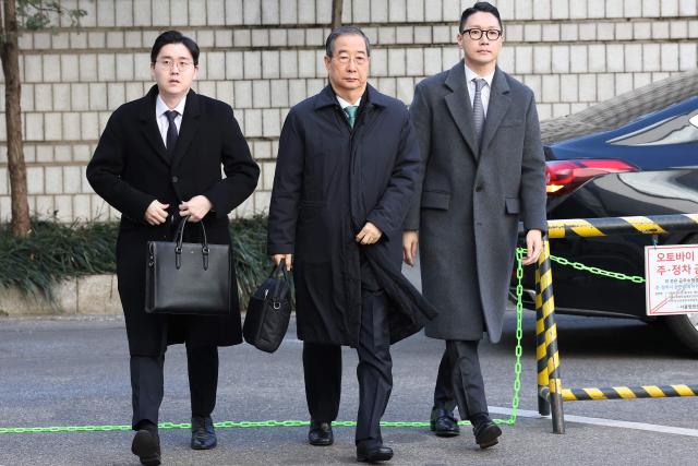 Former South Korean prime minister Han Duck-soo (C) arrives at the Seoul Central District Court for his first sentencing trial in the insurrection case in Seoul on January 21, 2026> (Photo by Chung Sung-Jun / POOL / AFP)