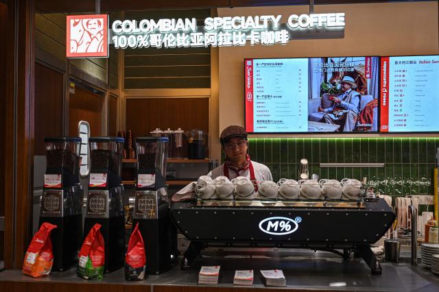 A barista, employee of the Colombian coffee brand Juan Valdez store waits for customers at China's first Juan Valdez Café in Shanghai on January 21, 2026. (Photo by Jade GAO / AFP)