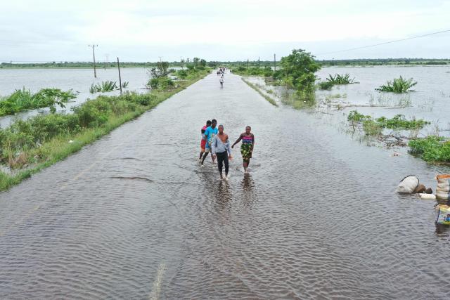 This aerial view shows residents wading through floodwater to cross a road near Maputo on January 20, 2026. At least 114 people have died since the rainy season began in early October 2025, including 51 since Christmas Eve, when downpours intensified and sent torrents of river water crashing through several villages.
The United Nations says the surging waters have spiralled into a rapidly escalating emergency. (Photo by Emidio JOZINE / AFP)
