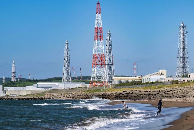 (FILES) This picture taken on August 5, 2024 shows people visiting Arahama beach in front of the Kashiwazaki-Kariwa nuclear power station in Kashiwazaki, in Japan's Niigata prefecture. The world's biggest nuclear power plant is set to restart on January 21, 2026, for the first time since the 2011 Fukushima disaster, its Japanese operator said, despite persistent safety concerns among residents. (Photo by Yuichi YAMAZAKI / AFP)