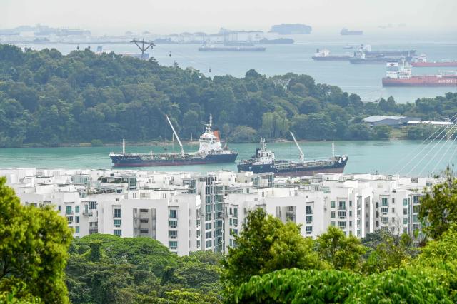Vessels sail along the harbourfront bay in Singapore on January 21, 2026. (Photo by Roslan RAHMAN / AFP)