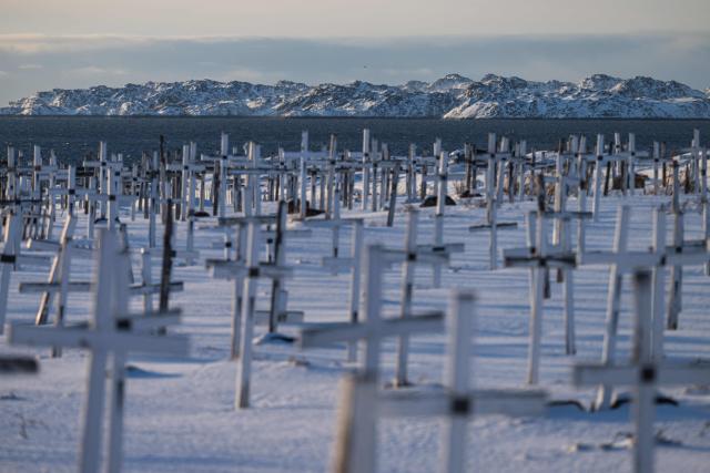 White crosses marking graves stand in a snow-covered cemetery overlooking the sea in Nuuk, Greenland, on January 20, 2026. (Photo by Jonathan NACKSTRAND / AFP)