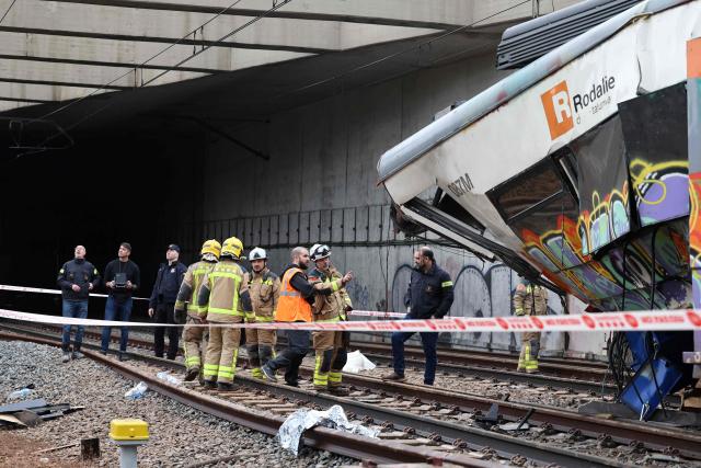 Firefighters and investigators stand next to the locomotive as they work at the site where at least one person died and five were seriously injured when a regional service train collided with a collapsed wall  between Sant Sadurni d'Anoia and Gelida, near Barcelona, on January 21, 2026. The latest incident is likely to raise more questions about Spanish rail safety after the collision of two high-speed trains in the southern region of Andalusia on Sunday killed 42 people and injured more than 120.  (Photo by Josep LAGO / AFP)