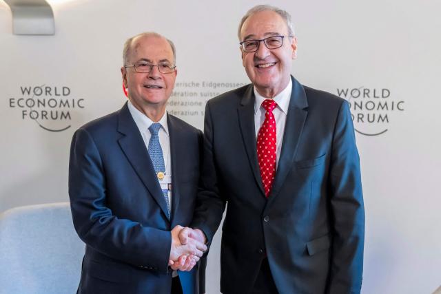 Palestinian Prime Minister Mohammad Mustafa (L) and Switzerland's Federal President Guy Parmelin shake hands during a bi-lateral meeting on the sidelines of the 56th annual meeting of the World Economic Forum (WEF) annual meeting in Davos on January 21, 2026. The World Economic Forum is taking place in Davos from January 19 to January 23, 2026. (Photo by LAURENT GILLIERON / POOL / AFP)