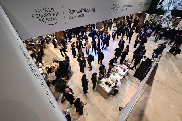 Visitors stand inside the Congress Centre during the World Economic Forum (WEF) annual meeting in Davos on January 21, 2026. The World Economic Forum takes place in Davos from January 19 to January 23, 2026. (Photo by Fabrice COFFRINI / AFP)