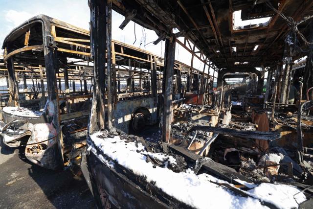 This photograph taken during a tour for foreign media shows the parked buses that were burnt at a depot during recent public protests, in Tehran on January 21, 2026. Demonstrations sparked in late December by anger over economic hardship exploded into protests widely seen as the biggest challenge to the Iranian leadership in years. Limited internet access briefly returned in Iran before dropping again, a monitor said January 18, 10 days into a communications blackout that rights groups said aimed to mask a protest crackdown that killed thousands. (Photo by ATTA KENARE / AFP)