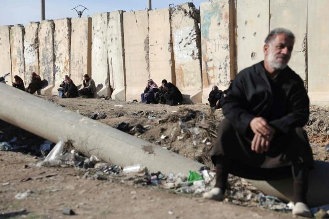 Family members of detainees in Al-Aqtan prison on the outskirts of the northeastern Syrian city of Raqa wait outside the facility as they try to have news about their detained relatives on January 21, 2026. The government announced a new ceasefire with the Kurds after taking swathes of north and east Syria that had long been under the control of Kurdish-led Syrian Democratic Forces (SDF). The United States, which has long headed an international coalition and backed the Kurds against IS, said the purpose of its alliance with the SDF had largely ended years after they defeated the jihadists. Now, the United States was backing Syria's new Islamist authorities who are seeking to extend their control across the country after years of civil war. (Photo by Bakr ALkasem / AFP)