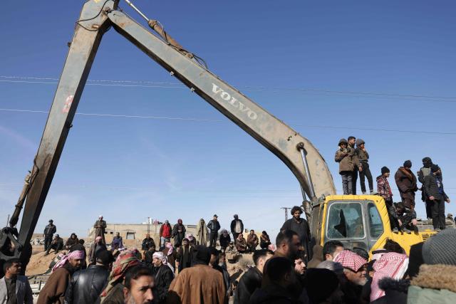 Family members of detainees in Al-Aqtan prison on the outskirts of the northeastern Syrian city of Raqa gather outside the facility as they try to have news about their detained relatives on January 21, 2026. The government announced a new ceasefire with the Kurds after taking swathes of north and east Syria that had long been under the control of Kurdish-led Syrian Democratic Forces (SDF). The United States, which has long headed an international coalition and backed the Kurds against IS, said the purpose of its alliance with the SDF had largely ended years after they defeated the jihadists. Now, the United States was backing Syria's new Islamist authorities who are seeking to extend their control across the country after years of civil war. (Photo by Bakr ALkasem / AFP)