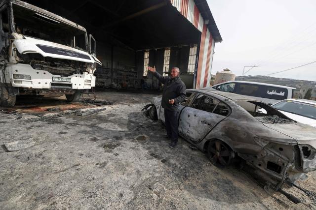 A Palestinian man inspects burnt vehicles following a reported attack by Israeli settlers at a stone works processing plant in Orif village near the Israeli-occupied northern West Bank city of Nablus on January 21, 2026. Israel has occupied the West Bank since 1967, and violence there has soared since the Gaza war erupted in October 2023 following Hamas's attack on Israel. Some 3,200 Palestinians from dozens of Bedouin and herding communities have been forced from their homes by settler violence and movement restrictions since October 2023, the UN's humanitarian agency OCHA reported in October. All Israeli settlements in the West Bank are considered illegal by the international community. (Photo by JAAFAR ASHTIYEH / AFP)