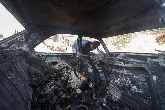 A Palestinian man inspects a burnt car following a reported attack by Israeli settlers at a stone works processing plant in Orif village near the Israeli-occupied northern West Bank city of Nablus on January 21, 2026. Israel has occupied the West Bank since 1967, and violence there has soared since the Gaza war erupted in October 2023 following Hamas's attack on Israel. Some 3,200 Palestinians from dozens of Bedouin and herding communities have been forced from their homes by settler violence and movement restrictions since October 2023, the UN's humanitarian agency OCHA reported in October. All Israeli settlements in the West Bank are considered illegal by the international community. (Photo by JAAFAR ASHTIYEH / AFP)