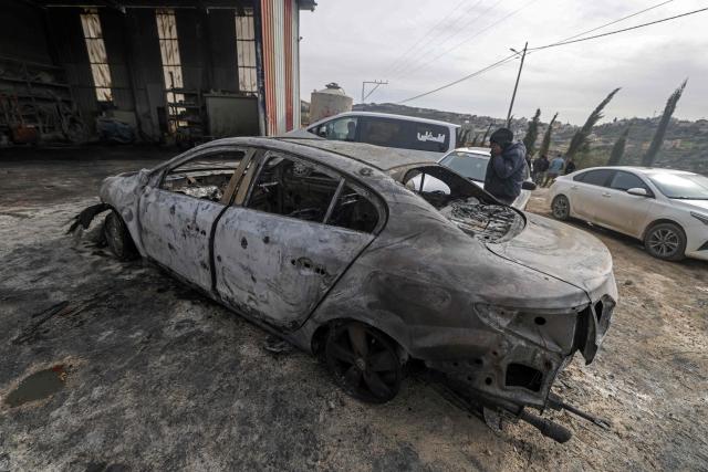 A Palestinian man inspects a burnt car following a reported attack by Israeli settlers at a stone works processing plant in Orif village near the Israeli-occupied northern West Bank city of Nablus on January 21, 2026. Israel has occupied the West Bank since 1967, and violence there has soared since the Gaza war erupted in October 2023 following Hamas's attack on Israel. Some 3,200 Palestinians from dozens of Bedouin and herding communities have been forced from their homes by settler violence and movement restrictions since October 2023, the UN's humanitarian agency OCHA reported in October. All Israeli settlements in the West Bank are considered illegal by the international community. (Photo by JAAFAR ASHTIYEH / AFP)