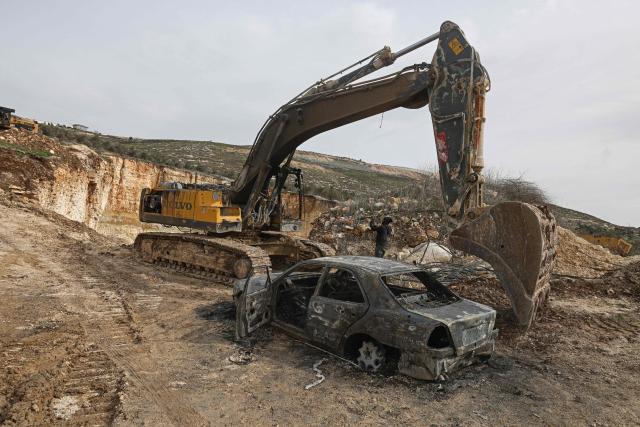 A Palestinian man inspects a burnt car and a bulldozer following a reported attack by Israeli settlers at a stone works processing plant in Orif village near the Israeli-occupied northern West Bank city of Nablus on January 21, 2026. Israel has occupied the West Bank since 1967, and violence there has soared since the Gaza war erupted in October 2023 following Hamas's attack on Israel. Some 3,200 Palestinians from dozens of Bedouin and herding communities have been forced from their homes by settler violence and movement restrictions since October 2023, the UN's humanitarian agency OCHA reported in October. All Israeli settlements in the West Bank are considered illegal by the international community. (Photo by JAAFAR ASHTIYEH / AFP)