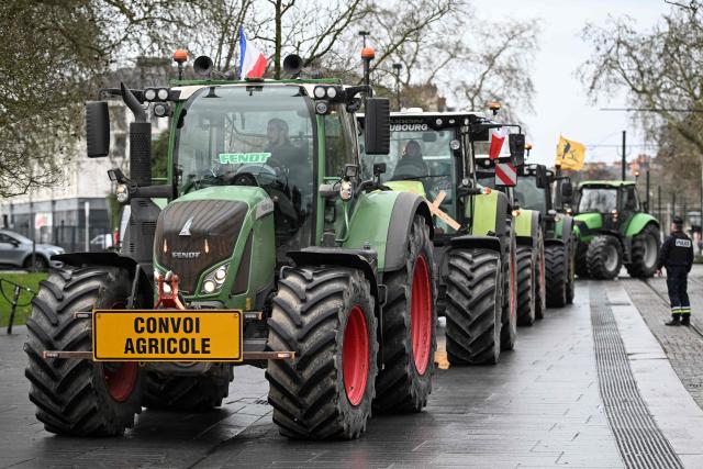 A French police officer stands next to parked tractors as farmers take part in a protest against the free trade agreement between the European Union and the Mercosur countries, on the day of a vote on a referral to the courts, in Strasbourg on January 21, 2026. The European Union's parliament voted on Janaury 21, 2026, to refer a freshly signed trade deal with South American bloc Mercosur to the EU's top court, casting a veil of legal uncertainty over the accord. (Photo by Sebastien Salom-Gomis / AFP)