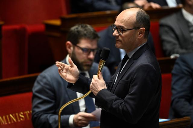 France's Housing Minister Vincent Jeanbrun (L) sits next to France’s junior Minister for industry Sebastien Martin addressing MPs during a session of questions to the government at The National Assembly, France's lower house parliament, in Paris on January 21, 2026. (Photo by JULIEN DE ROSA / AFP)