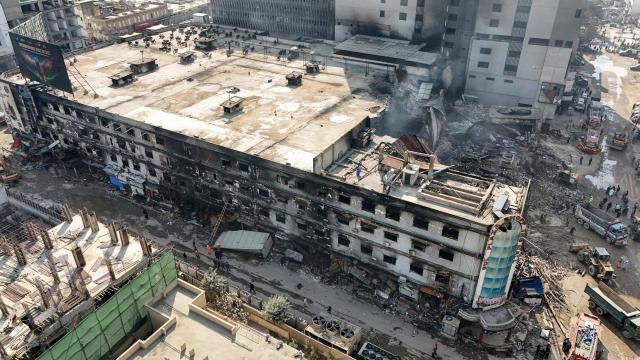 An aerial view shows the charred remains of a shopping mall after a massive fire in Karachi on January 21, 2026. A fire that ripped through a shopping mall in Pakistan's biggest city has killed at least 21 people, rescuers in Karachi said on January 19. (Photo by Israr AHMED KHAN / AFP)