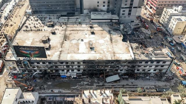 An aerial view shows the charred remains of a shopping mall after a massive fire in Karachi on January 21, 2026. A fire that ripped through a shopping mall in Pakistan's biggest city has killed at least 21 people, rescuers in Karachi said on January 19. (Photo by Israr AHMED KHAN / AFP)