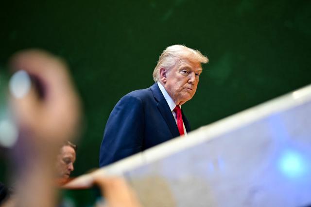 US President Donald Trump looks on as he leaves after addressing a speech during the World Economic Forum (WEF) annual meeting in Davos on January 21, 2026. The World Economic Forum takes place in Davos from January 19 to January 23, 2026. (Photo by Fabrice COFFRINI / AFP)