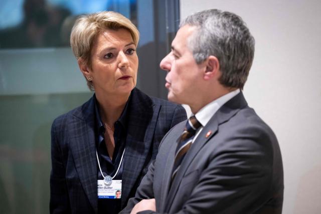Switzerland's Foreign Minister Federal councillor Ignazio Cassis (R) and Switzerland's Economy Minister Federal councillor Karin Keller-Sutter wait in a corridor of the Congress Centre prior to a bilateral meeting with US Secratary of State Marco Rubio and US  Treasury Secretary Scott Bessent, White House Chief of Staff Susie Wiles and US Ambassador to Switzerland, Callista Gingrich, on the sidelines of the 56th annual meeting of the World Economic Forum (WEF) in Davos on January 21, 2026. The World Economic Forum is taking place in Davos from January 19 to January 23, 2026. (Photo by LAURENT GILLIERON / POOL / AFP)