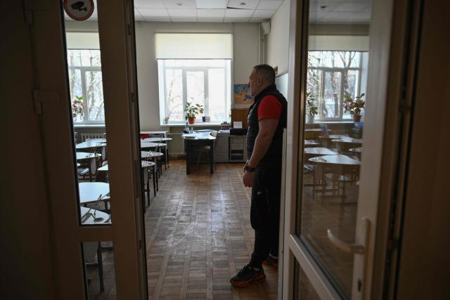 Headmaster Fedir Hubenkov, 41, shows an empty classroom in a school in Kyiv on January 21, 2026, after schools in the capital closed until February due to Russian missile and drone attacks on Ukrainian energy infrastructure, amid the Russian invasion in Ukraine. Schools in Ukrainian capital Kyiv will be closed until the next month, mayor Vitali Klitschko announced December 16, 2026, citing "difficult conditions" after Russian strikes battered the energy sector amid below-freezing temperatures. (Photo by Genya SAVILOV / AFP)