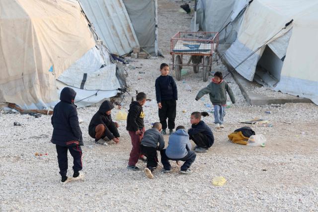 Children, relatives of suspected Islamic State jihadists, play inside Al-Hol camp in the desert region of Syria's Hasakeh province on January 21, 2026. Syria's army entered the vast Al-Hol camp that houses relatives of suspected Islamic State jihadists after Kurdish forces withdrew from the site, said an AFP journalist at the scene. The camp in a desert region of Hasakeh province holds around 24,000 people, including some 6,200 women and children from around 40 nationalities. (Photo by OMAR HAJ KADOUR / AFP)