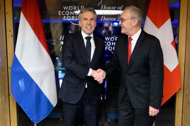 Swiss Federal President Guy Parmelin (R) shakes hands with Netherlands' Prime Minister Dick Schoof (L) prior to a bilateral meeting at the House of Switzerland on the sidelines of the World Economic Forum (WEF) annual meeting in Davos on January 21, 2026. The World Economic Forum takes place in Davos from January 19 to January 23, 2026. (Photo by LAURENT GILLIERON / AFP)