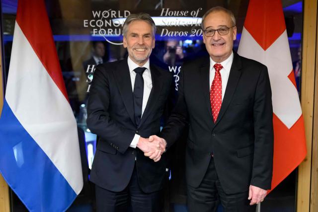 Swiss Federal President Guy Parmelin (R) shakes hands with Netherlands' Prime Minister Dick Schoof (L) prior to a bilateral meeting at the House of Switzerland on the sidelines of the World Economic Forum (WEF) annual meeting in Davos on January 21, 2026. The World Economic Forum takes place in Davos from January 19 to January 23, 2026. (Photo by LAURENT GILLIERON / AFP)