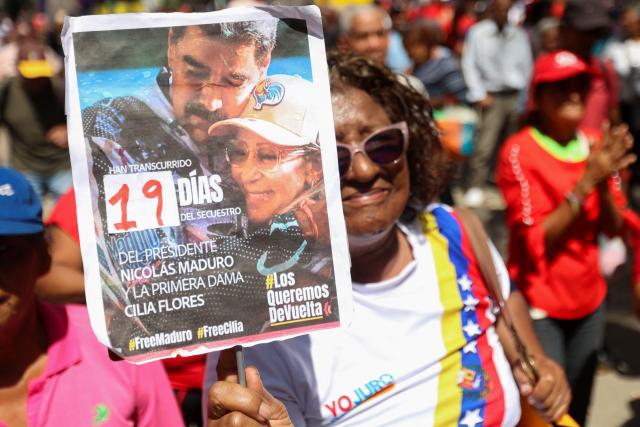 A man shows a sign during a demonstration by elder people to demand the release of ousted Venezuelan President Nicolas Maduro and his wife Cilia Flores in Caracas on January 21, 2026. (Photo by Pedro MATTEY / AFP)