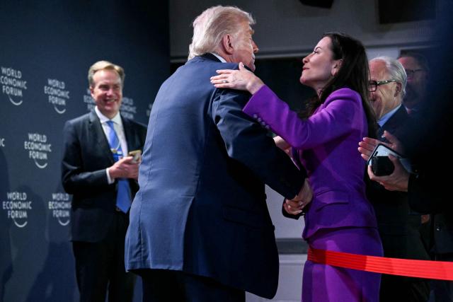 US President Donald Trump (L) greets former Deputy National Security Advisor of the US Dina Powell McCormick during a reception with business leaders on the sidelines of the World Economic Forum (WEF) annual meeting in Davos on January 21, 2026. The World Economic Forum takes place in Davos from January 19 to January 23, 2026. (Photo by Mandel NGAN / AFP)