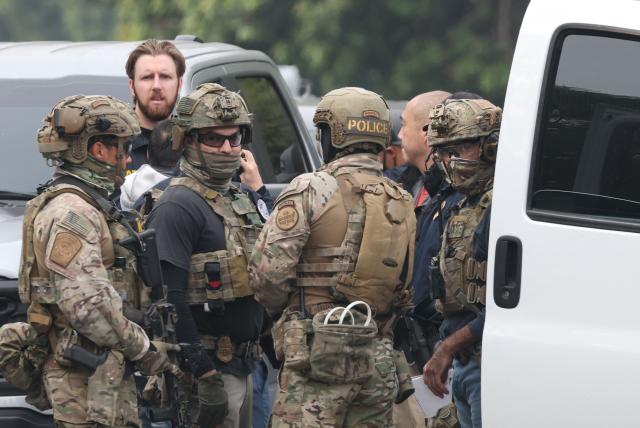 Federal agents investigate the scene of a reported shooting during an operation by federal immigration officers in Willowbrook, California, near Los Angeles, on January 21, 2026. According to media reports, no one was injured in the incident and suspects were arrested. Crowds of protesters have clashed with immigration officers in Minneapolis, particularly since the fatal shooting of a US woman by a federal agent on January 7. (Photo by Patrick T. Fallon / AFP)