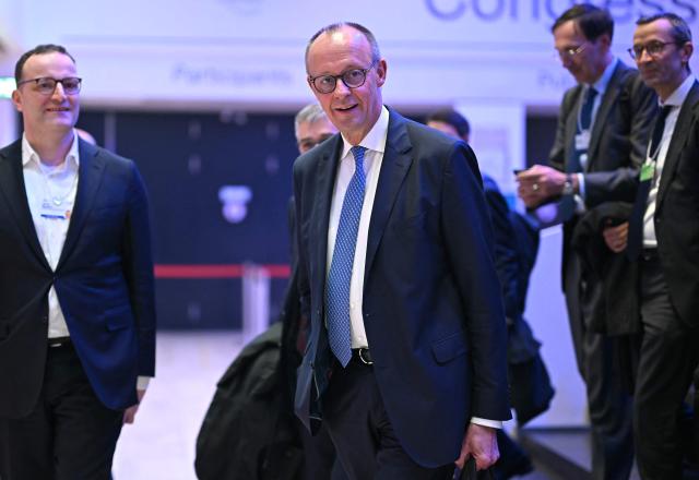 Germany's Chancellor Friedrich Merz (C) attends the World Economic Forum (WEF) annual meeting in Davos on January 21, 2026. The World Economic Forum takes place in Davos from January 19 to January 23, 2026. (Photo by Fabrice COFFRINI / AFP)