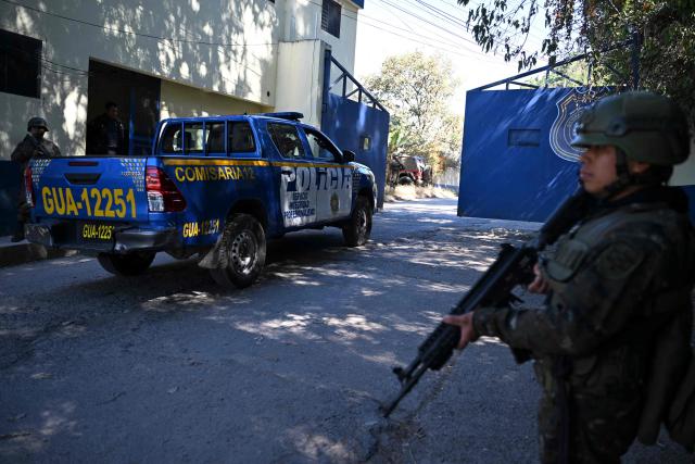A Guatemalan police patrol by the entrance to the men's Preventive Detention Center in Guatemala City on January 21, 2026, during a state of emergency declared by the national government. Guatemalan soldiers began patrolling gang-controlled neighborhoods in the capital on January 20, 2026, following recent attacks that killed 10 police officers, according to government sources and an AFP journalist. (Photo by Johan ORDÓÑEZ / AFP)